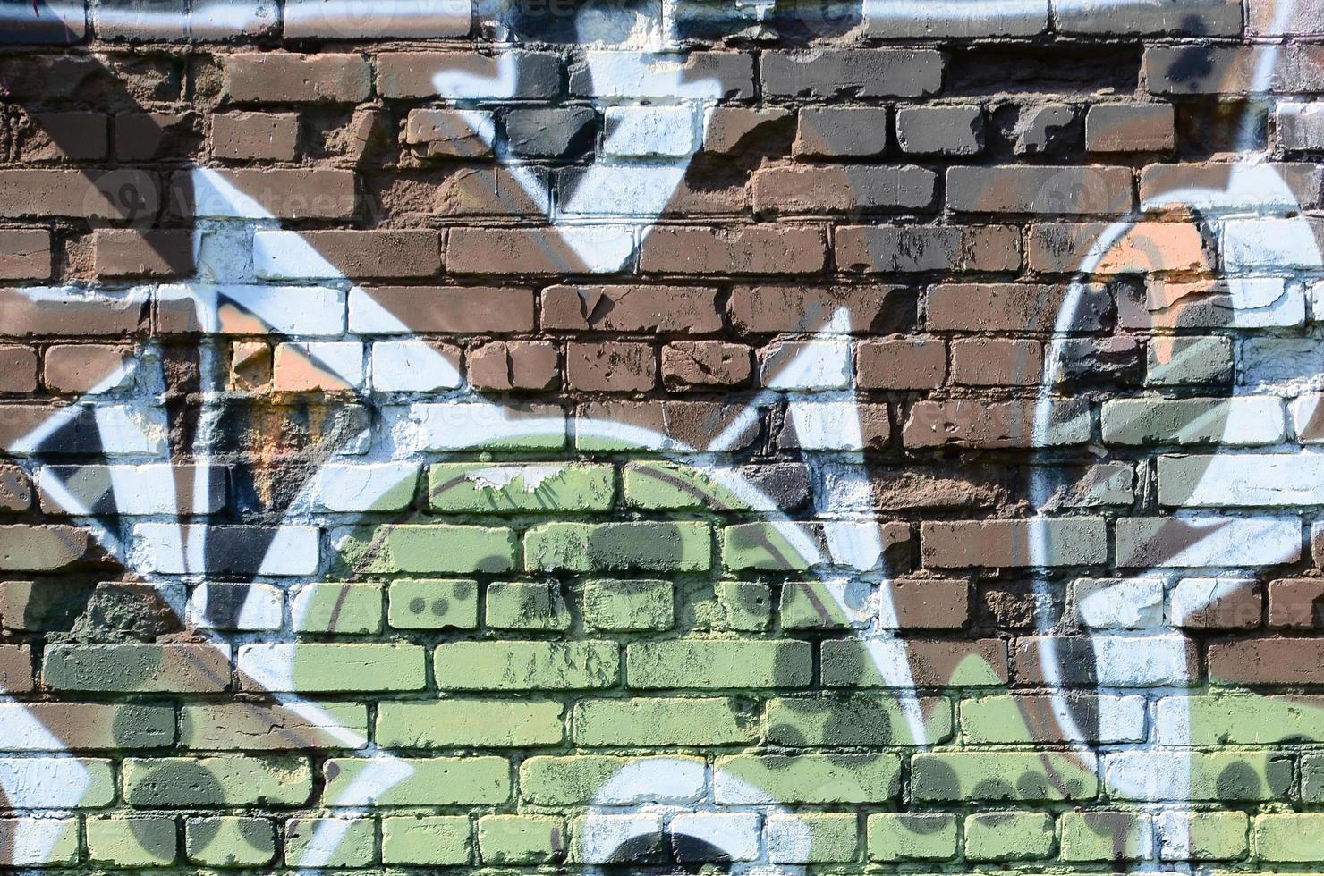 Fragment of graffiti drawings. The old wall decorated with paint stains in the style of street art culture. Colored background texture in warm tones photo