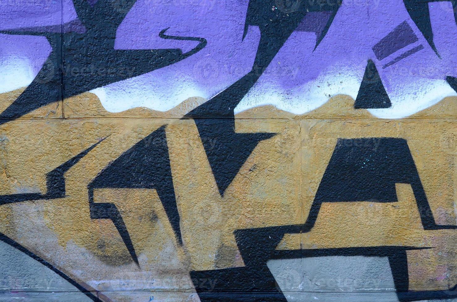 Fragment of graffiti drawings. The old wall decorated with paint stains in the style of street art culture. Colored background texture in purple tones photo