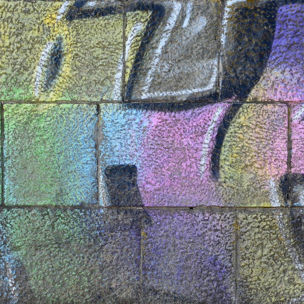 Fragment of graffiti drawings. The old wall decorated with paint stains in the style of street art culture. Multicolored background texture photo