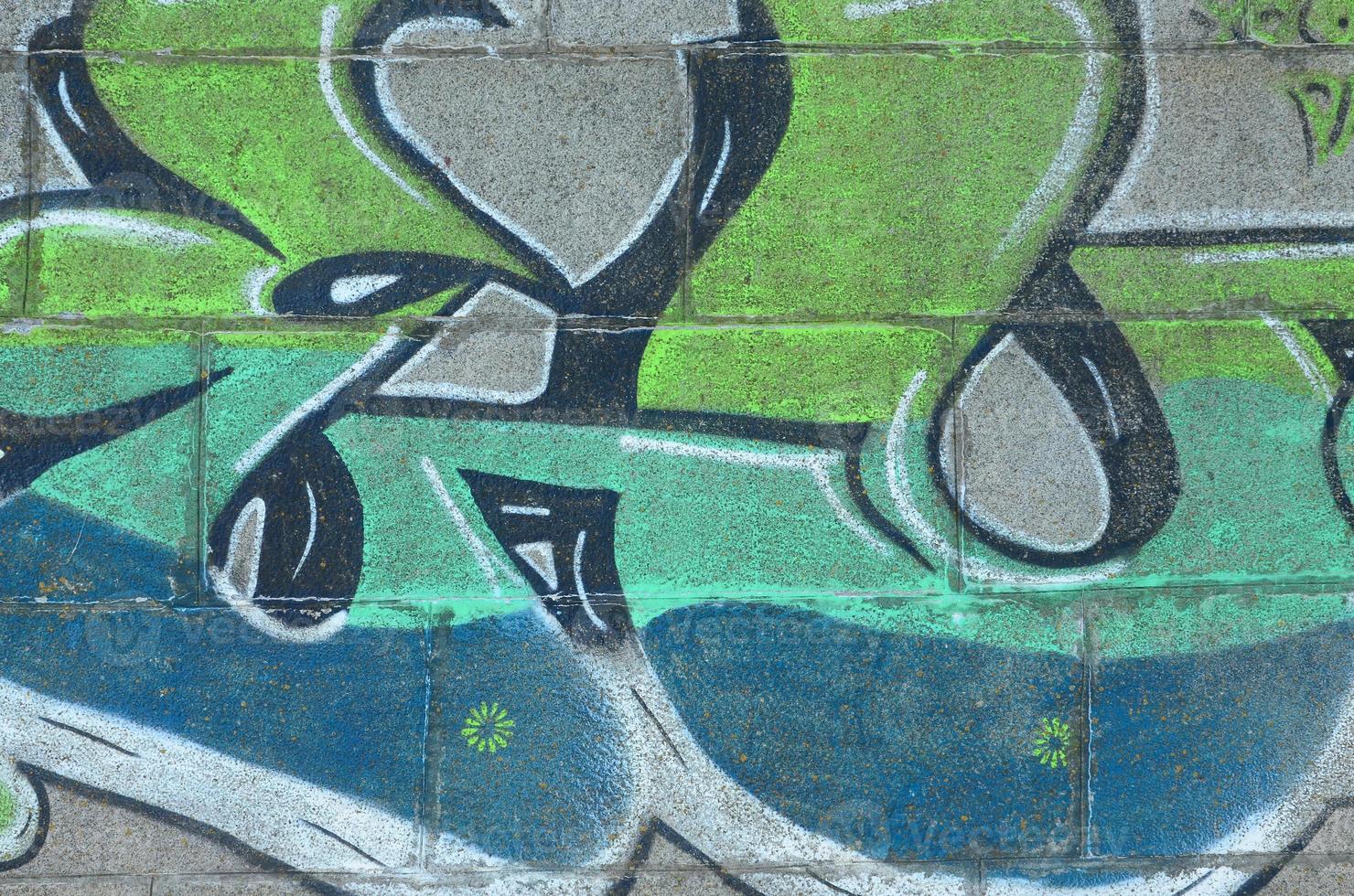 Fragment of graffiti drawings. The old wall decorated with paint stains in the style of street art culture. Colored background texture in green tones photo