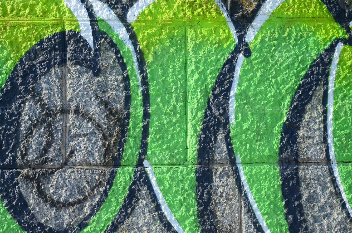 fragmento de dibujos de graffiti. la antigua muralla decorada con manchas de pintura al estilo de la cultura del arte callejero. textura de fondo coloreada en tonos verdes foto