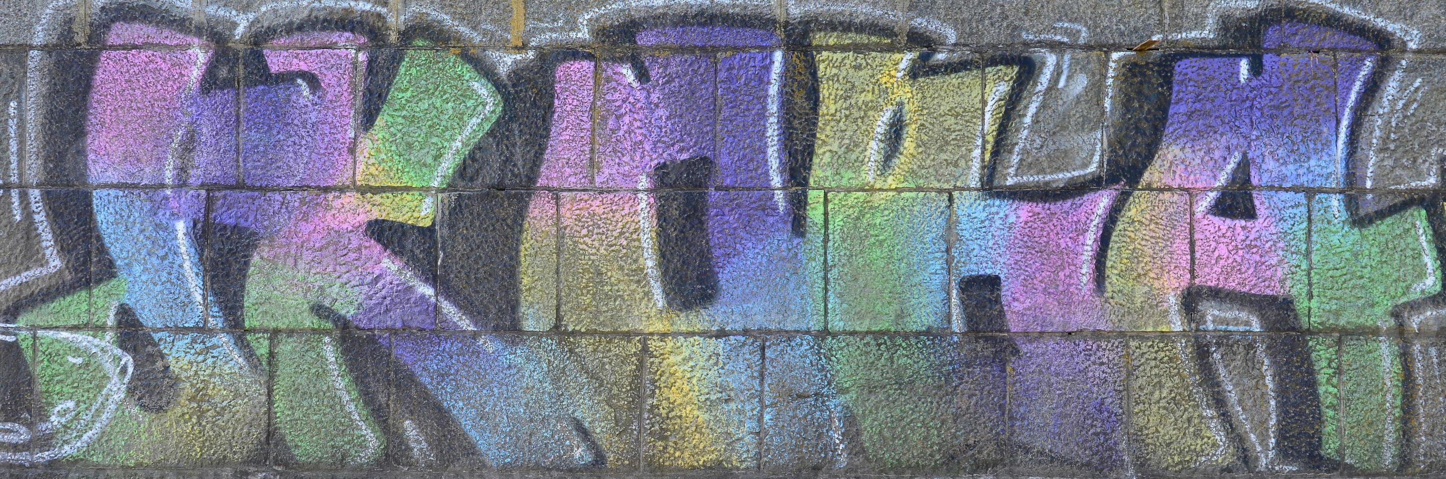 Fragment of graffiti drawings. The old wall decorated with paint stains in the style of street art culture. Multicolored background texture photo