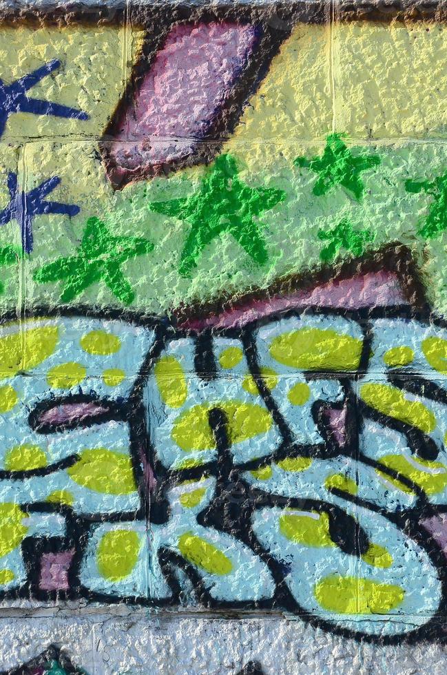 fragmento de dibujos de graffiti. la antigua muralla decorada con manchas de pintura al estilo de la cultura del arte callejero. textura de fondo coloreada en tonos verdes foto