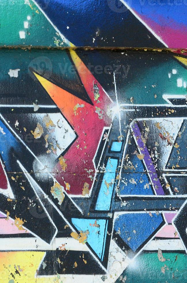 Fragment of graffiti drawings. The old wall decorated with paint stains in the style of street art culture. Multicolored background texture photo