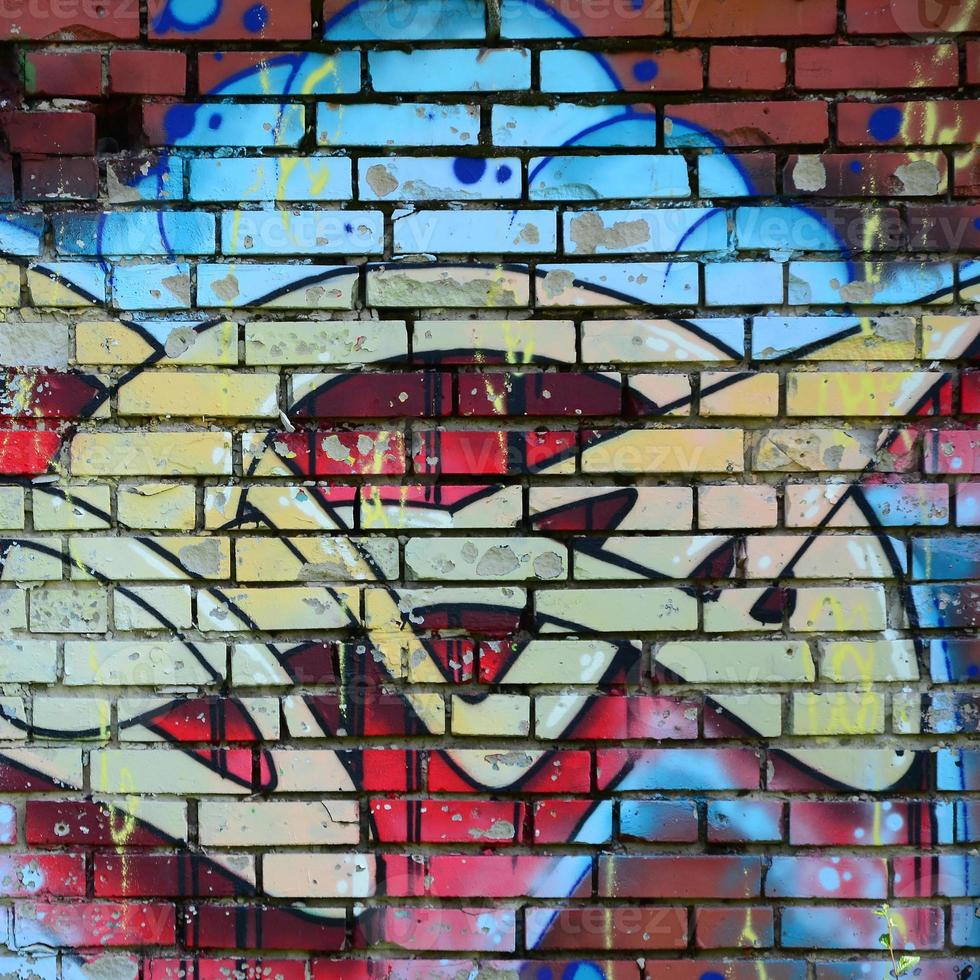 Fragment of graffiti drawings. The old wall decorated with paint stains in the style of street art culture. Colored background texture in warm tones photo