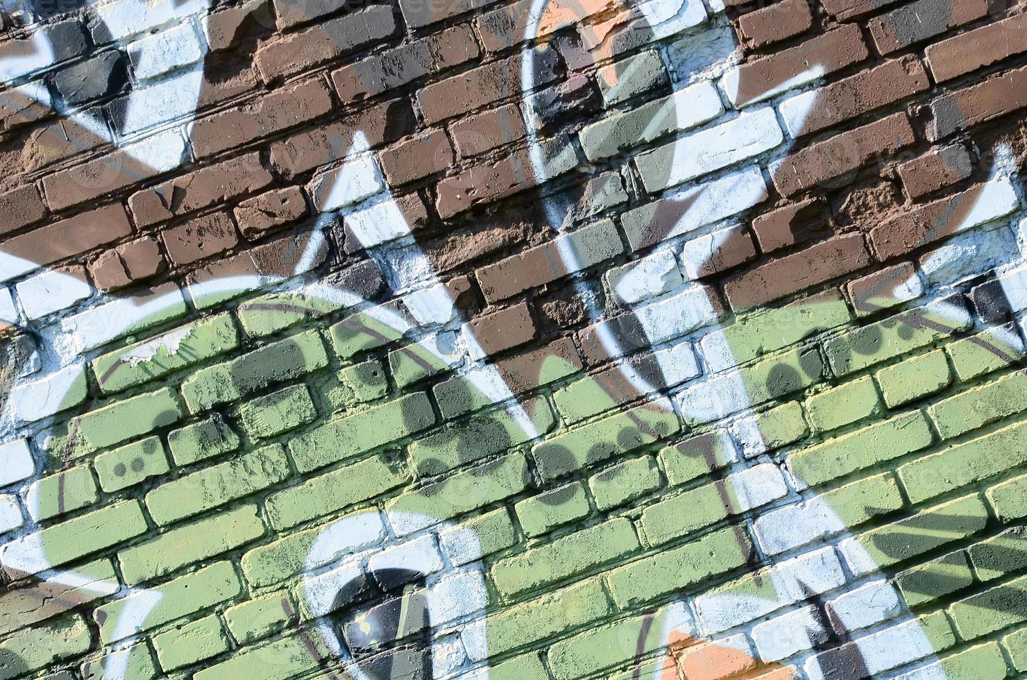 Fragment of graffiti drawings. The old wall decorated with paint stains in the style of street art culture. Colored background texture in warm tones photo