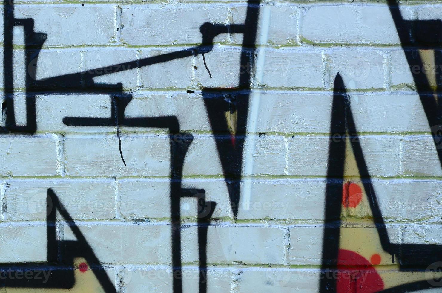 Fragment of graffiti drawings. The old wall decorated with paint stains in the style of street art culture. Colored background texture photo