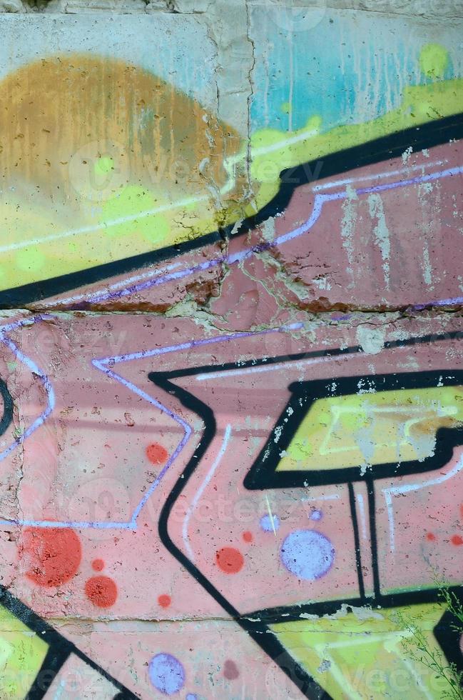Fragment of graffiti drawings. The old wall decorated with paint stains in the style of street art culture. Colored background texture in warm tones photo