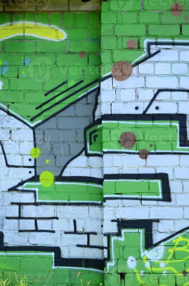 Fragment of graffiti drawings. The old wall decorated with paint stains in the style of street art culture. Colored background texture in green tones photo