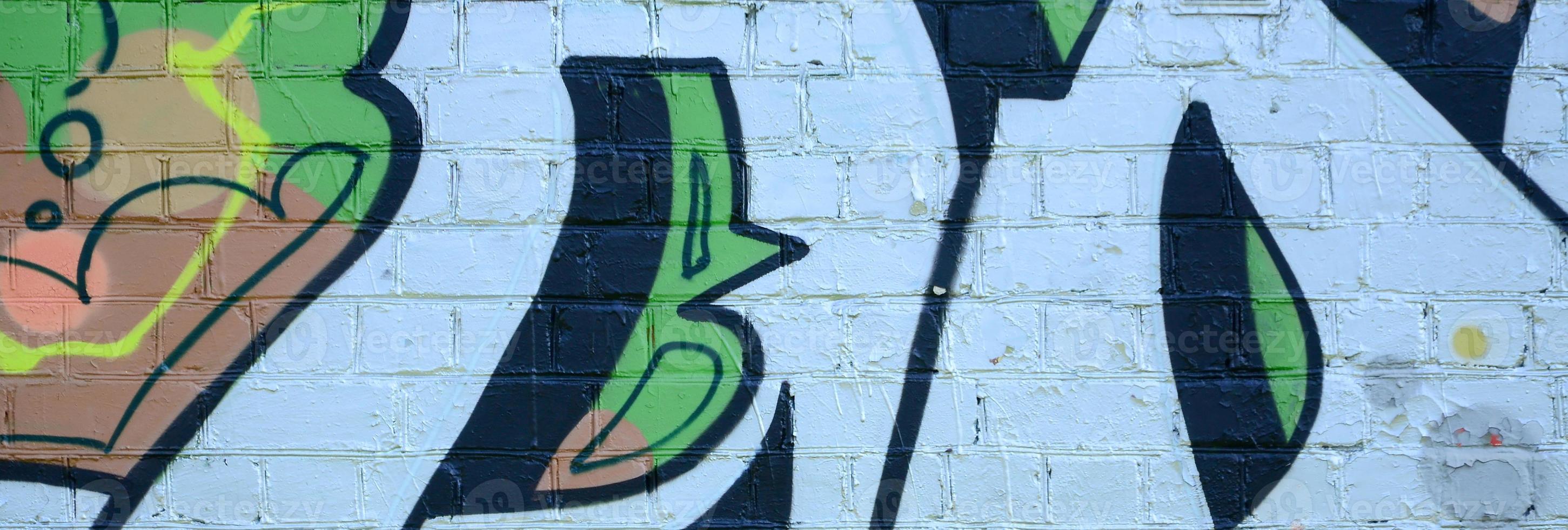 fragmento de dibujos de graffiti. la antigua muralla decorada con manchas de pintura al estilo de la cultura del arte callejero. textura de fondo coloreada en tonos verdes foto