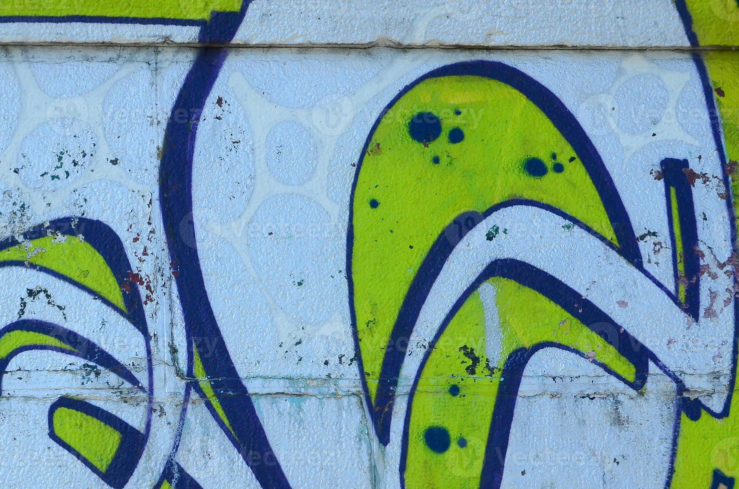 Fragment of graffiti drawings. The old wall decorated with paint stains in the style of street art culture. Colored background texture in green tones photo