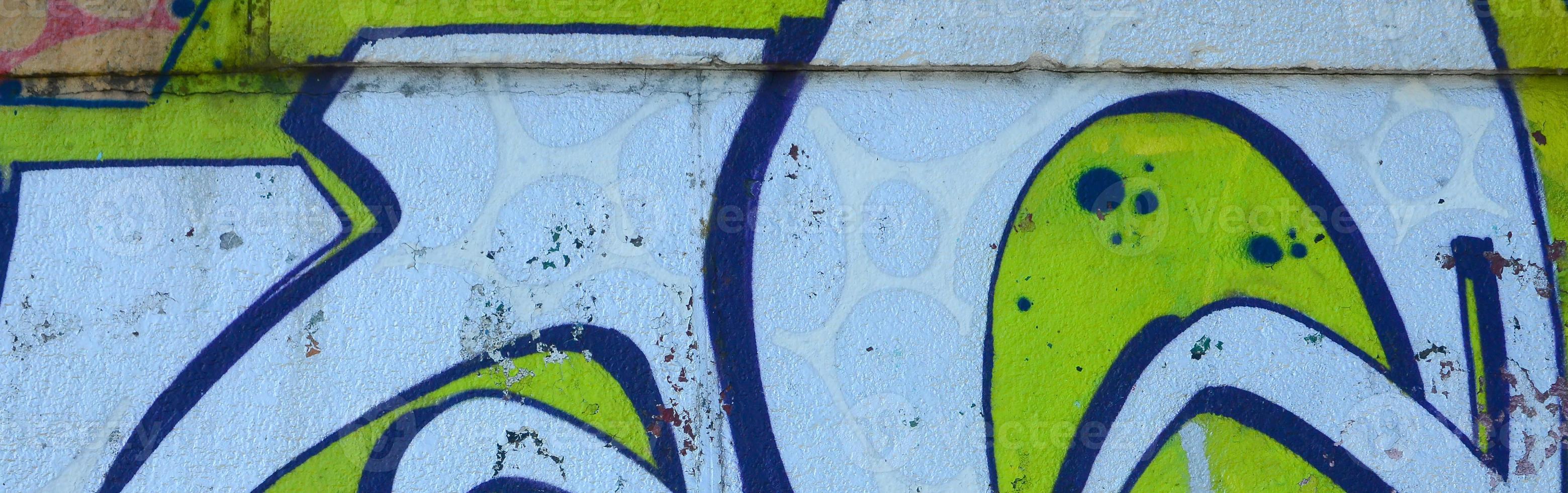 Fragment of graffiti drawings. The old wall decorated with paint stains in the style of street art culture. Colored background texture in green tones photo