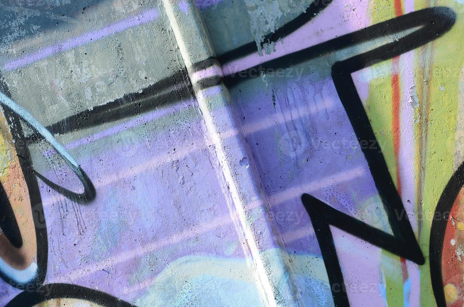 Fragment of graffiti drawings. The old wall decorated with paint stains in the style of street art culture. Multicolored background texture photo