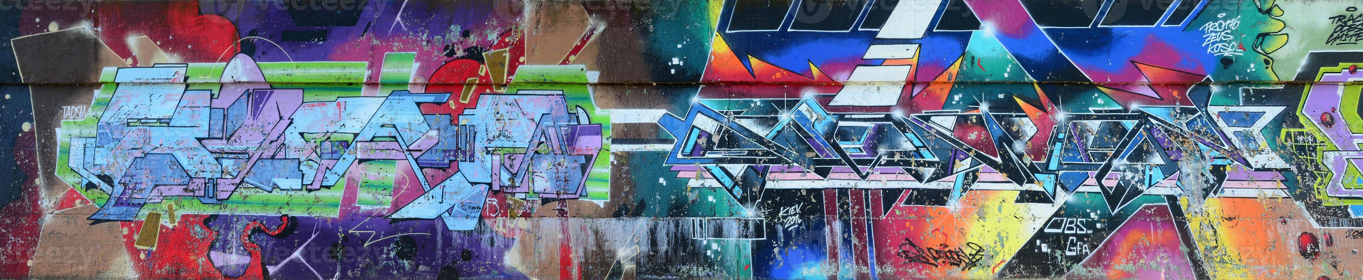 Fragment of graffiti drawings. The old wall decorated with paint stains in the style of street art culture. Multicolored background texture photo