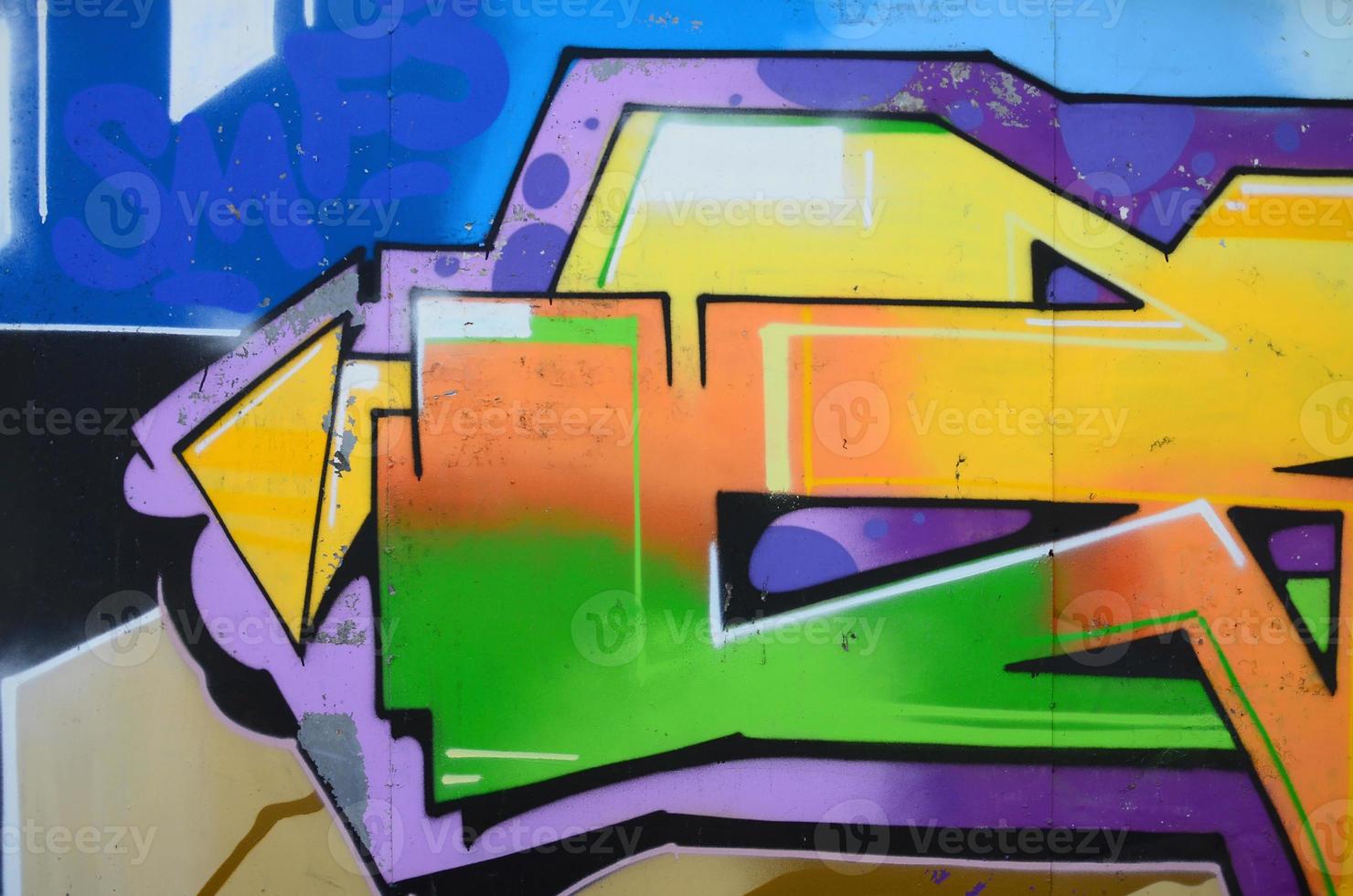 Fragment of graffiti drawings. The old wall decorated with paint stains in the style of street art culture. Multicolored background texture photo