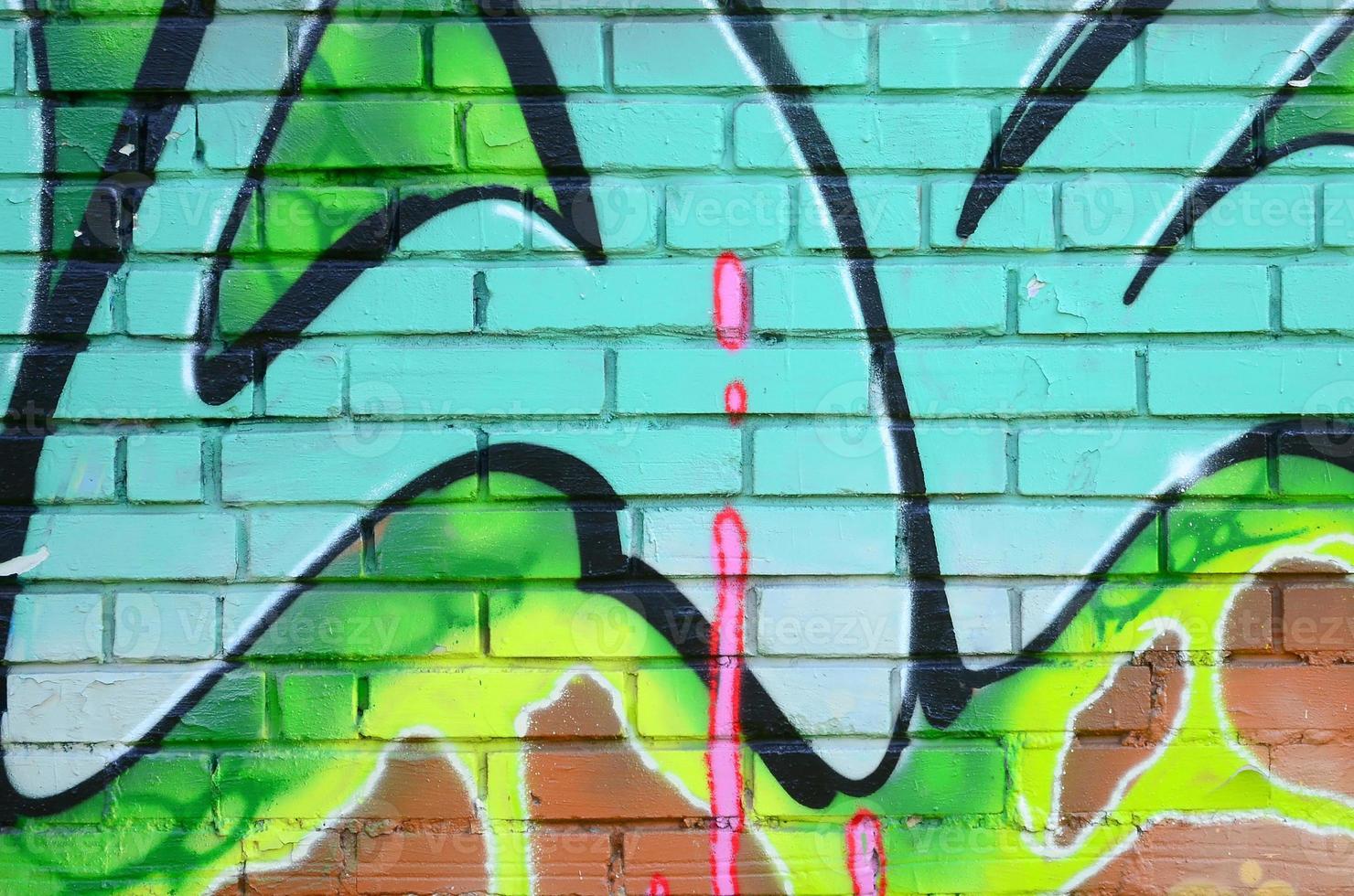Fragment of graffiti drawings. The old wall decorated with paint stains in the style of street art culture. Colored background texture in green tones photo