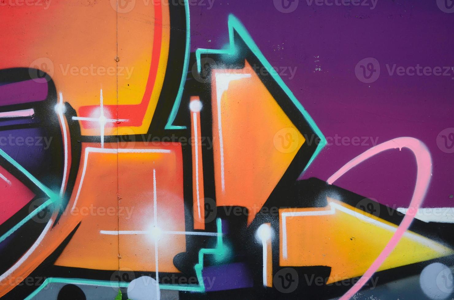 Fragment of graffiti drawings. The old wall decorated with paint stains in the style of street art culture. Colored background texture in warm tones photo