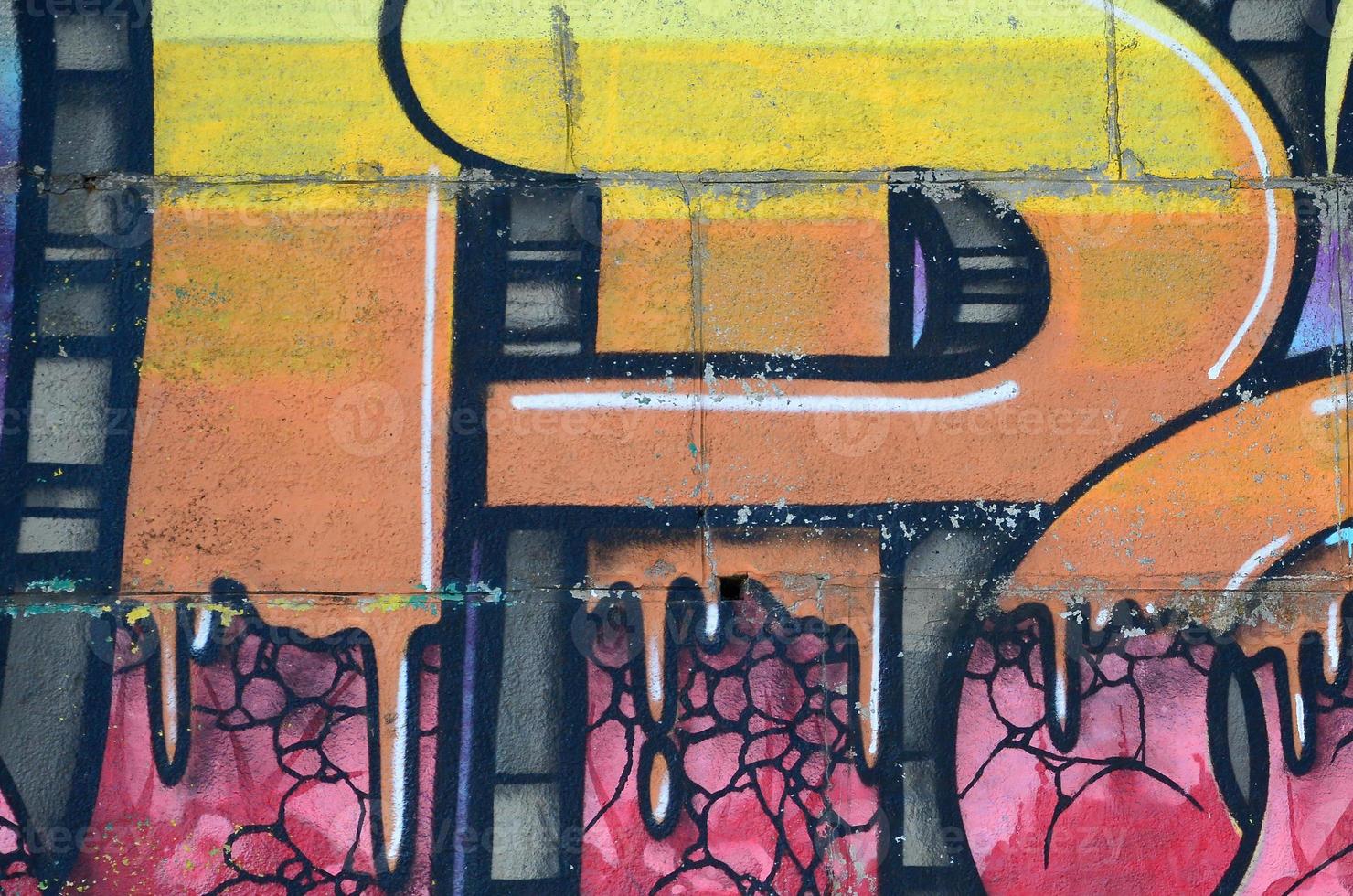 Fragment of graffiti drawings. The old wall decorated with paint stains in the style of street art culture. Colored background texture in warm tones photo