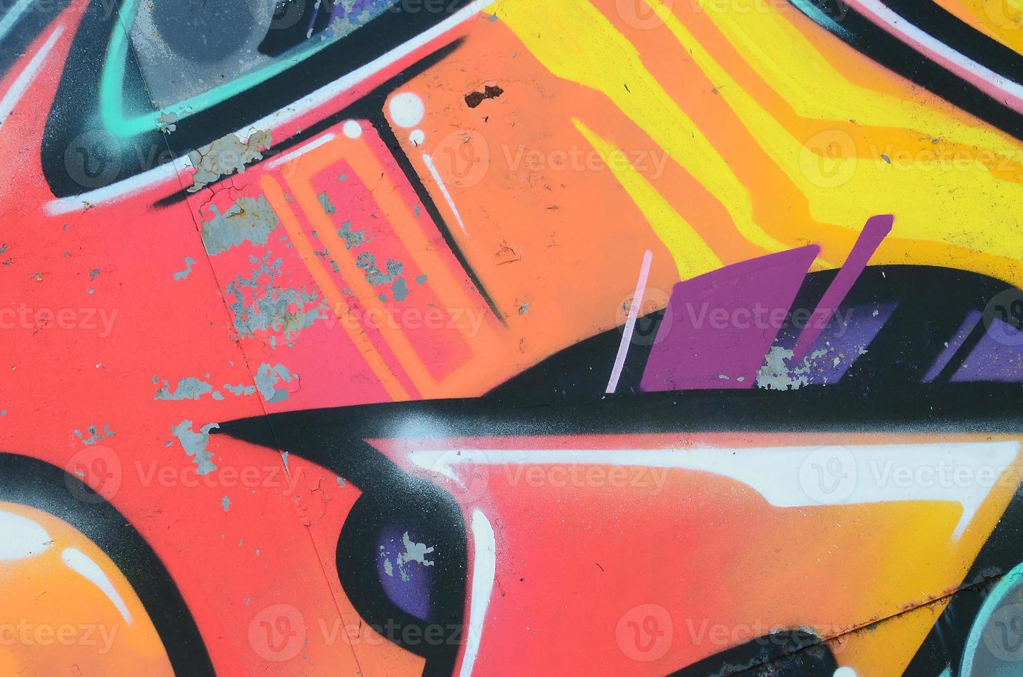 Fragment of graffiti drawings. The old wall decorated with paint stains in the style of street art culture. Colored background texture in warm tones photo