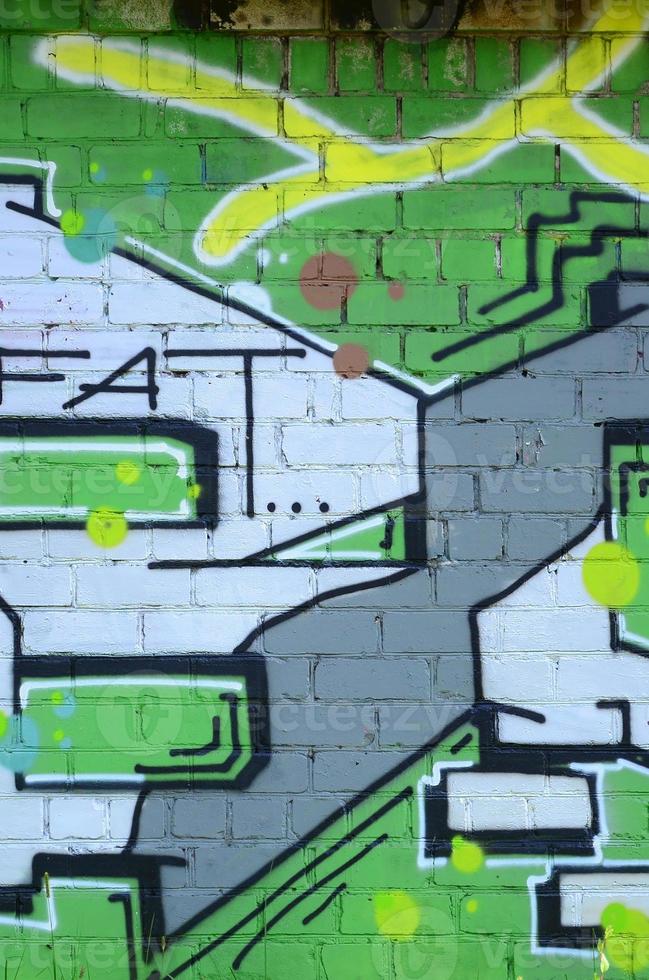 Fragment of graffiti drawings. The old wall decorated with paint stains in the style of street art culture. Colored background texture in green tones photo