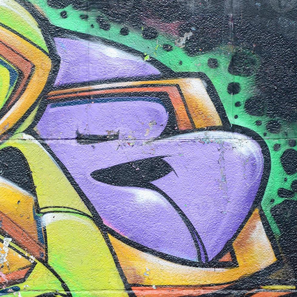 fragmento de dibujos de graffiti. la antigua muralla decorada con manchas de pintura al estilo de la cultura del arte callejero. textura de fondo multicolor foto