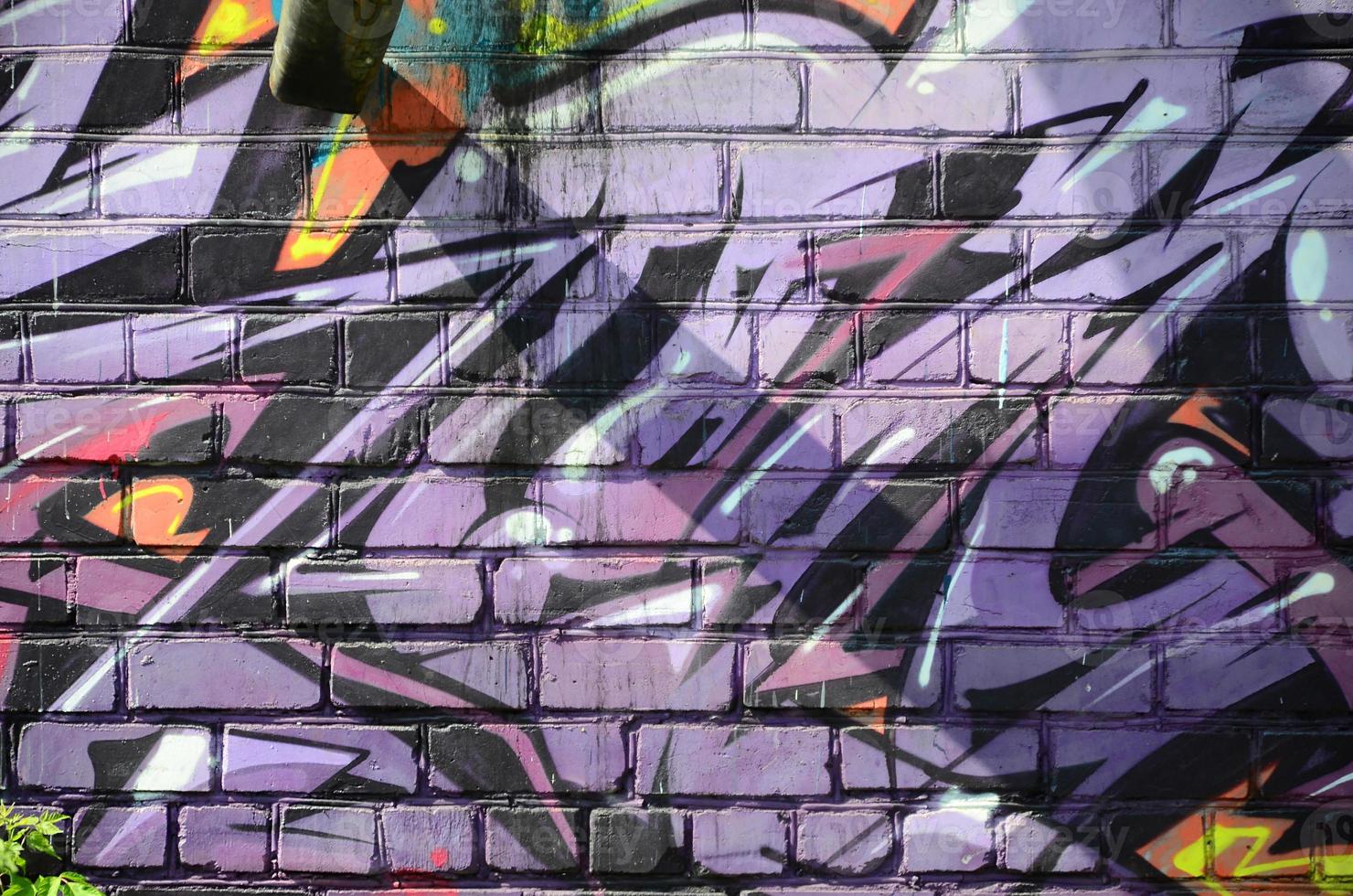 Fragment of graffiti drawings. The old wall decorated with paint stains in the style of street art culture. Colored background texture in purple tones photo
