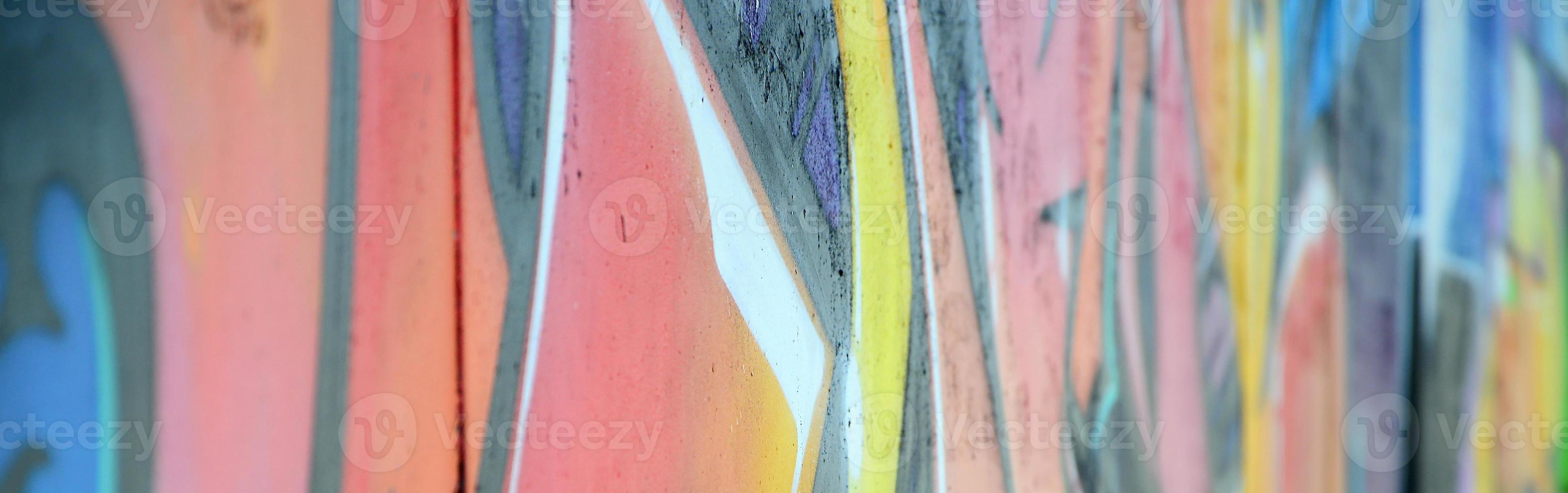 Fragment of graffiti drawings. The old wall decorated with paint stains in the style of street art culture. Colored background texture in warm tones photo