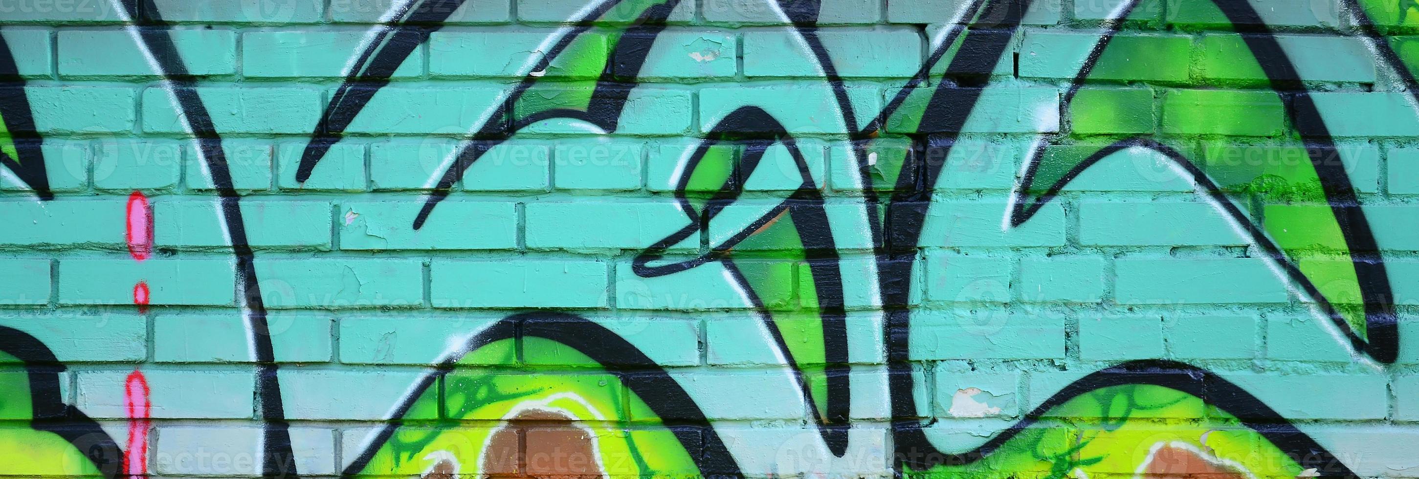 Fragment of graffiti drawings. The old wall decorated with paint stains in the style of street art culture. Colored background texture in green tones photo