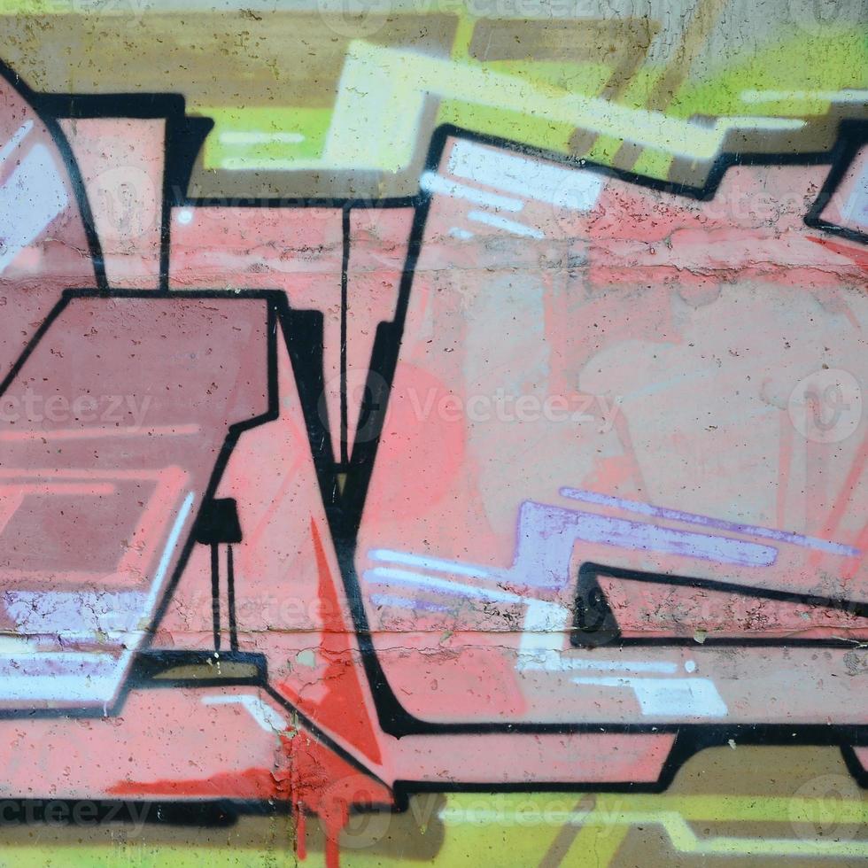 Fragment of graffiti drawings. The old wall decorated with paint stains in the style of street art culture. Colored background texture in warm tones photo