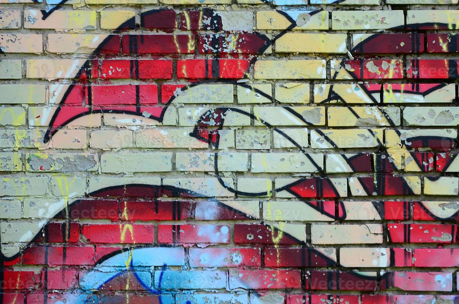 Fragment of graffiti drawings. The old wall decorated with paint stains in the style of street art culture. Colored background texture in warm tones photo