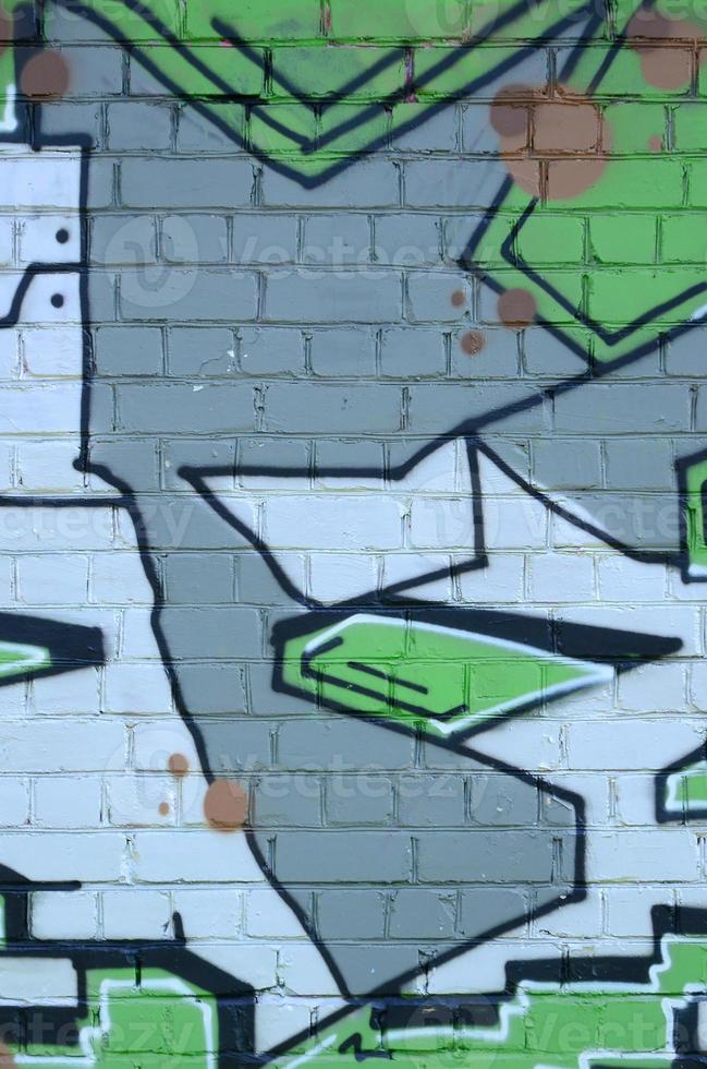 Fragment of graffiti drawings. The old wall decorated with paint stains in the style of street art culture. Colored background texture in green tones photo