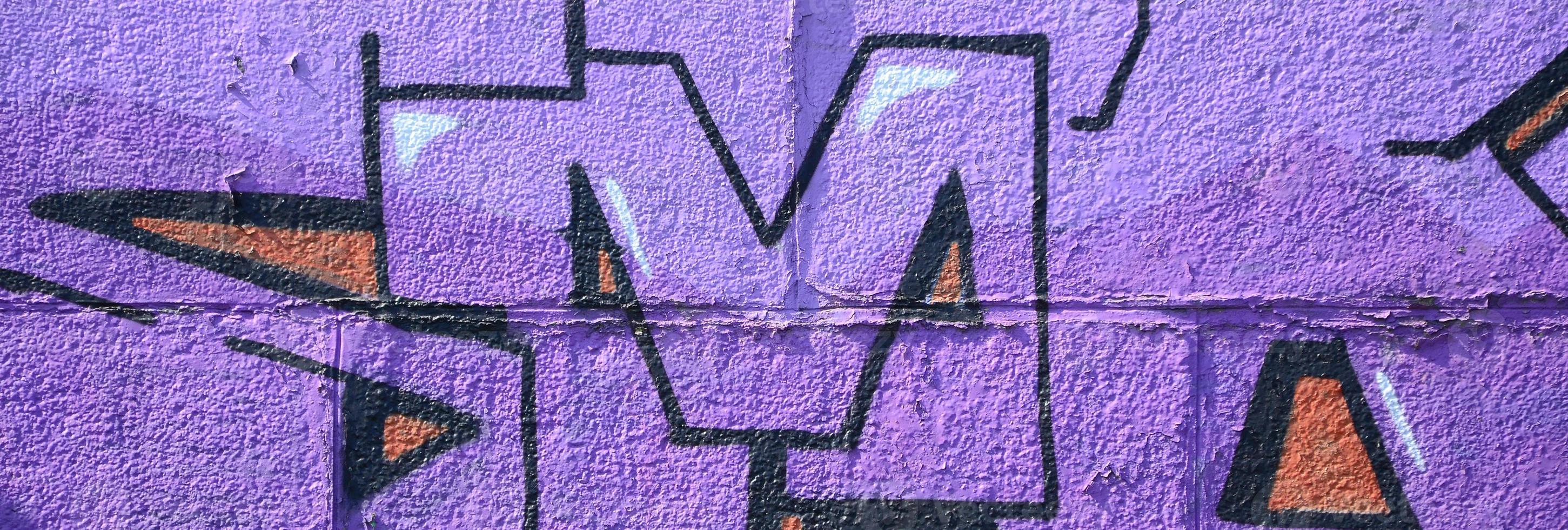 Fragment of graffiti drawings. The old wall decorated with paint stains in the style of street art culture. Colored background texture in purple tones photo