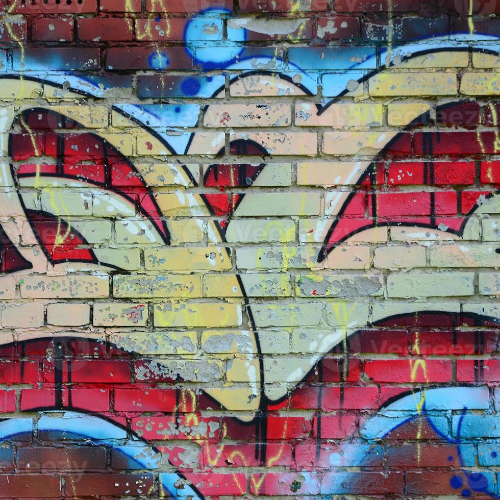 fragmento de dibujos de graffiti. la antigua muralla decorada con manchas de pintura al estilo de la cultura del arte callejero. textura de fondo coloreada en tonos cálidos foto