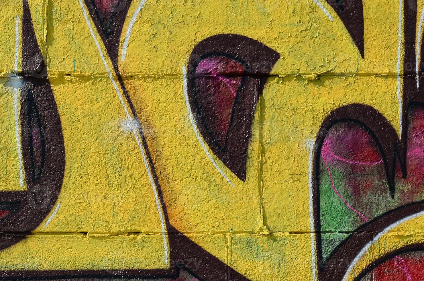 Fragment of graffiti drawings. The old wall decorated with paint stains in the style of street art culture. Colored background texture in warm tones photo