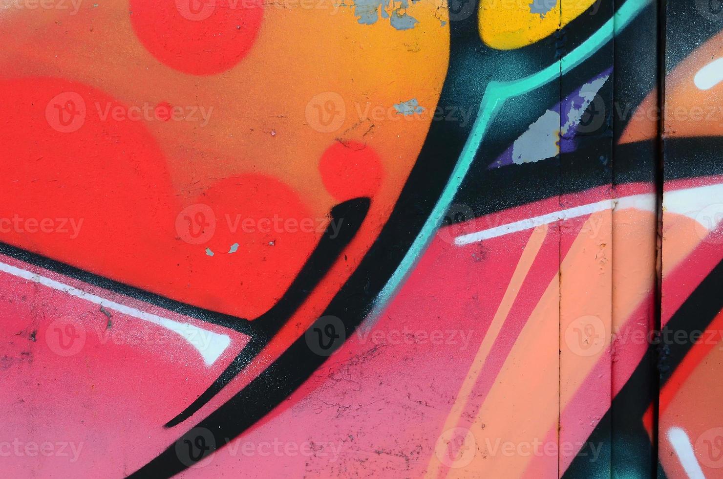 Fragment of graffiti drawings. The old wall decorated with paint stains in the style of street art culture. Colored background texture in warm tones photo