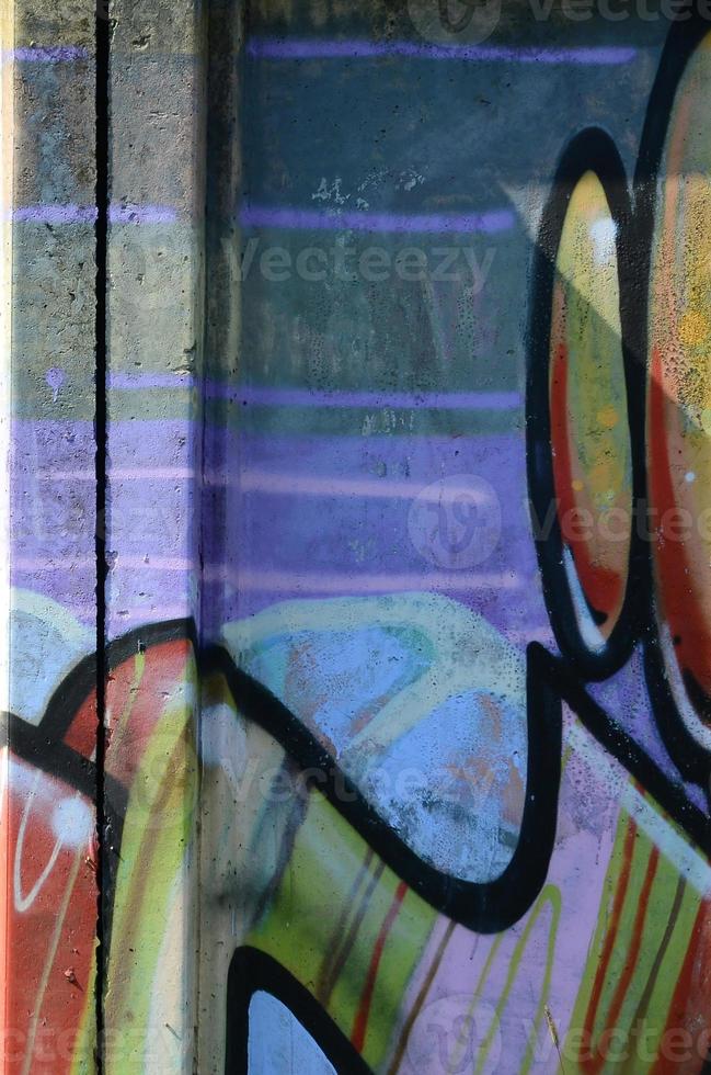 Fragment of graffiti drawings. The old wall decorated with paint stains in the style of street art culture. Multicolored background texture photo