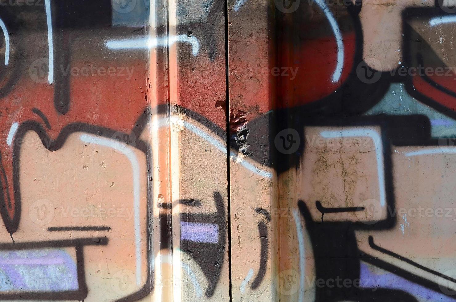 Fragment of graffiti drawings. The old wall decorated with paint stains in the style of street art culture. Colored background texture in warm tones photo