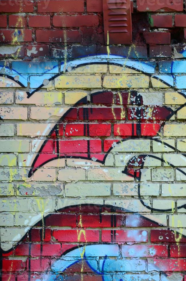 Fragment of graffiti drawings. The old wall decorated with paint stains in the style of street art culture. Colored background texture in warm tones photo