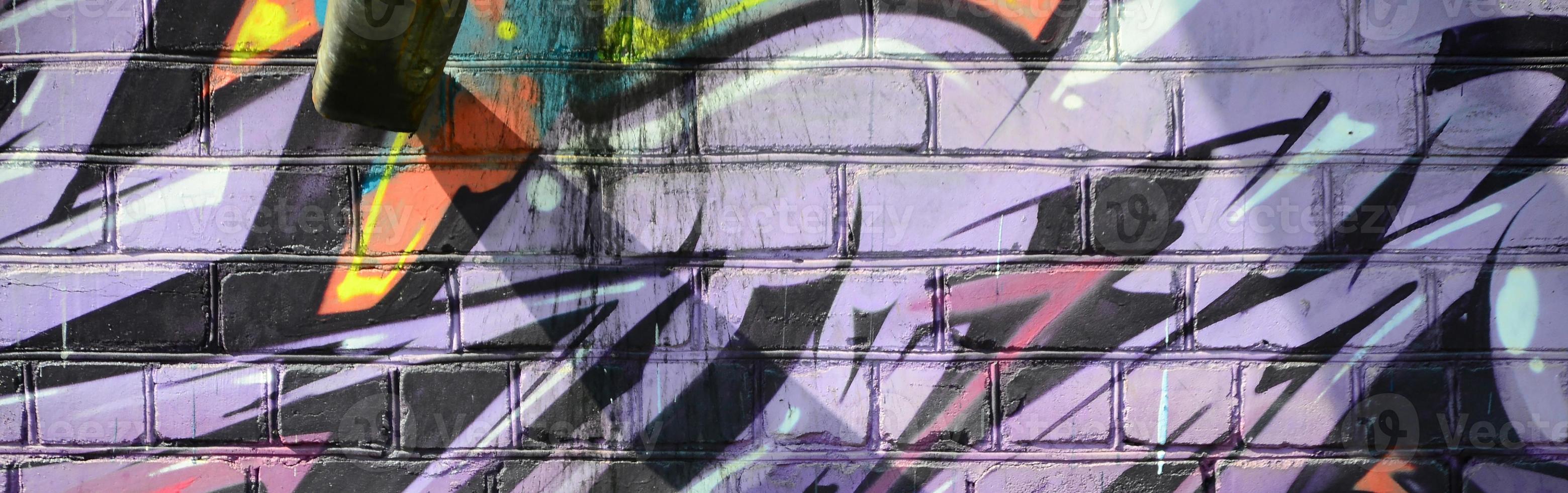 Fragment of graffiti drawings. The old wall decorated with paint stains in the style of street art culture. Colored background texture in purple tones photo