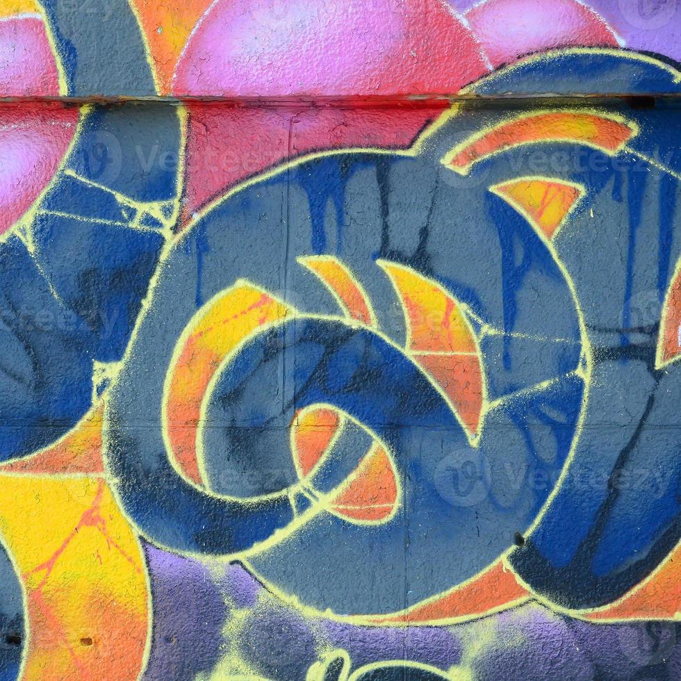 Fragment of graffiti drawings. The old wall decorated with paint stains in the style of street art culture. Multicolored background texture photo