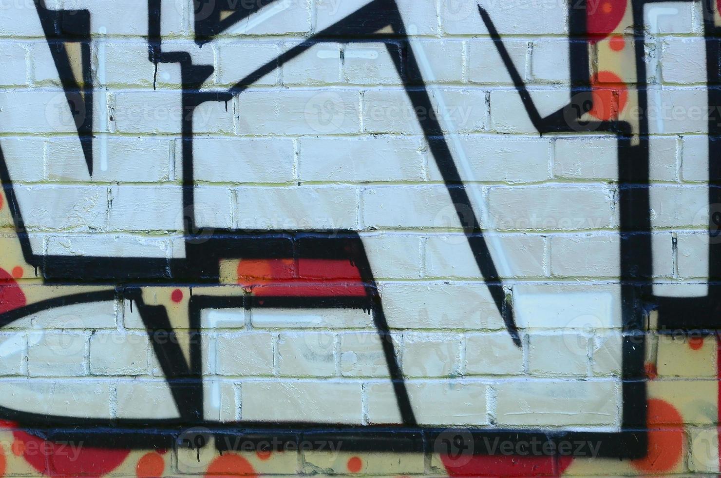 Fragment of graffiti drawings. The old wall decorated with paint stains in the style of street art culture. Colored background texture photo