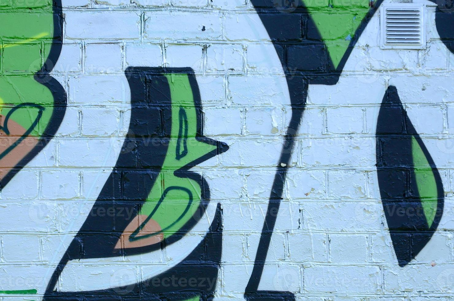 Fragment of graffiti drawings. The old wall decorated with paint stains in the style of street art culture. Colored background texture in green tones photo