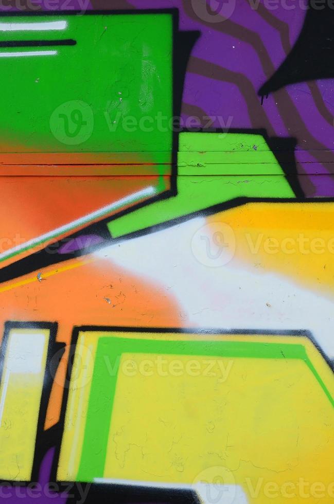 Fragment of graffiti drawings. The old wall decorated with paint stains in the style of street art culture. Multicolored background texture photo