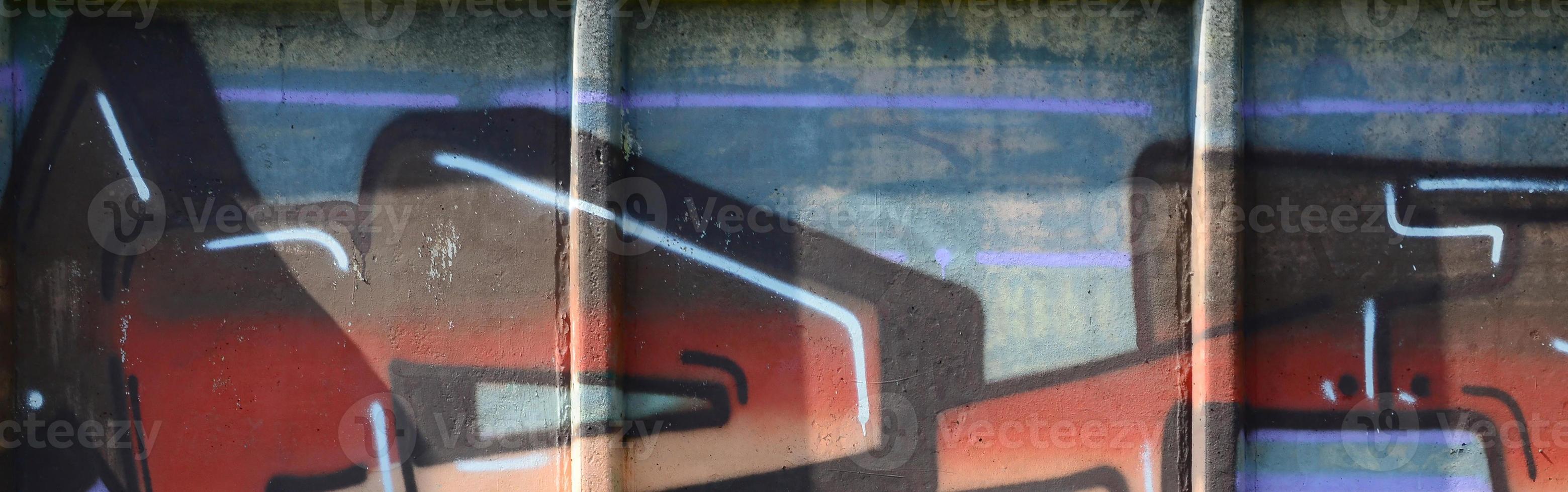 Fragment of graffiti drawings. The old wall decorated with paint stains in the style of street art culture. Colored background texture in warm tones photo