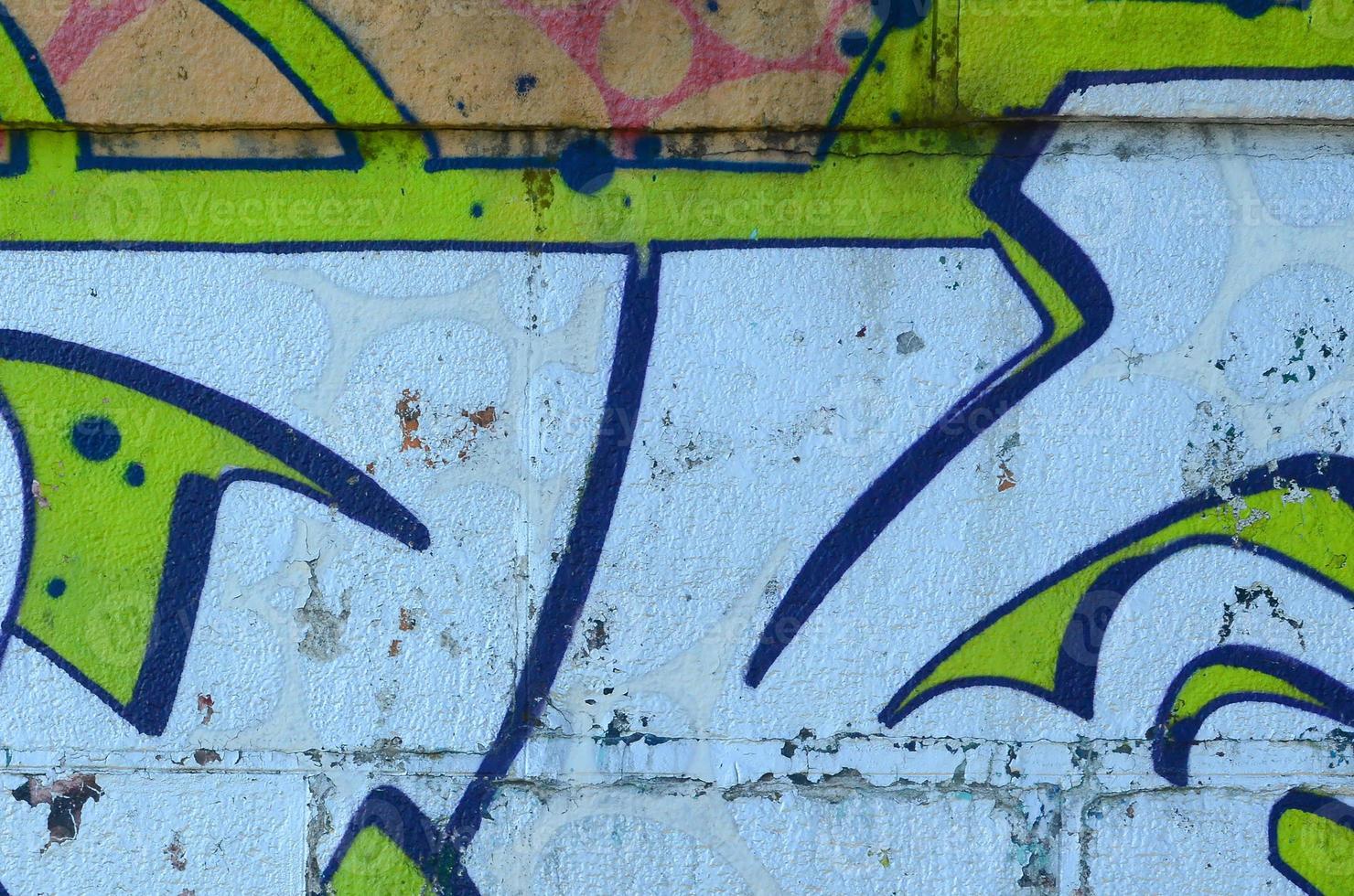 Fragment of graffiti drawings. The old wall decorated with paint stains in the style of street art culture. Colored background texture in green tones photo
