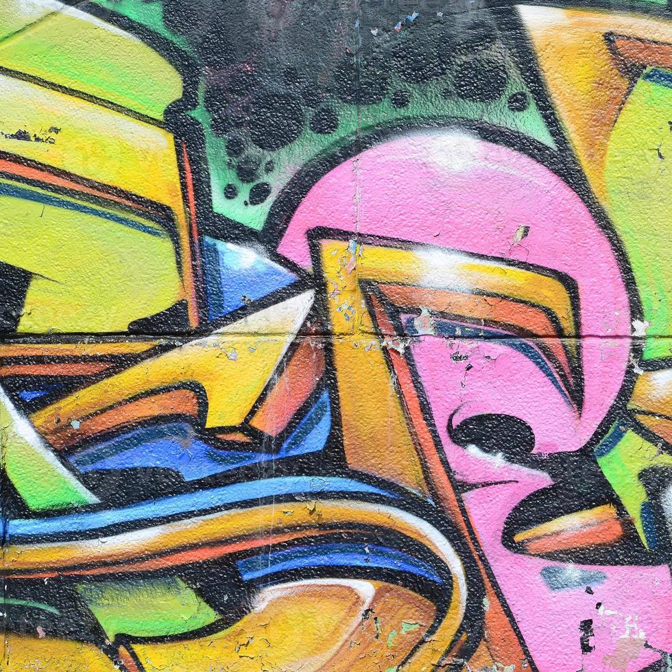 Fragment of graffiti drawings. The old wall decorated with paint stains in the style of street art culture. Multicolored background texture photo