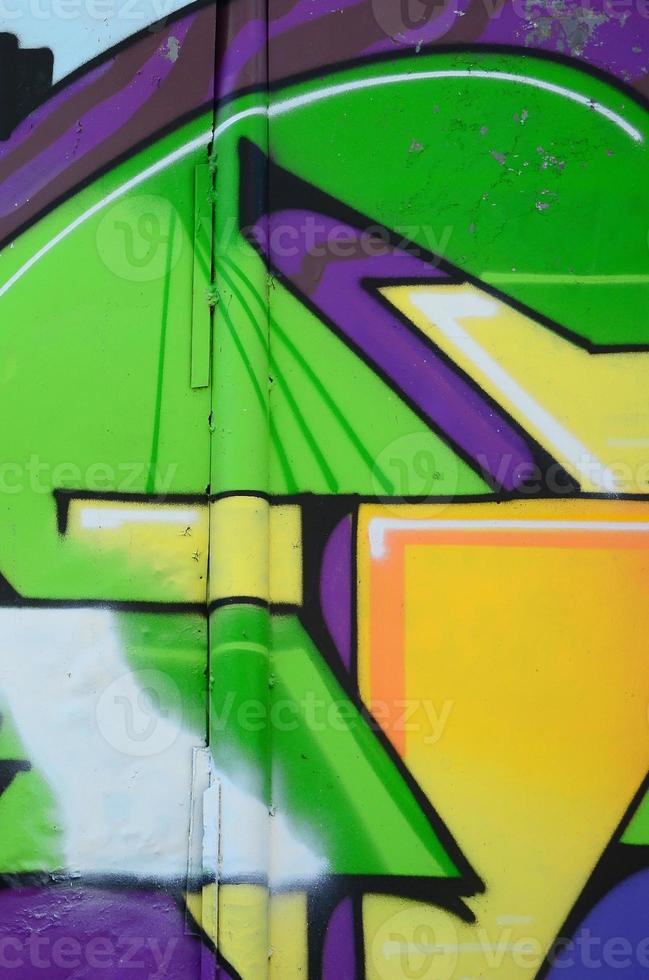 Fragment of graffiti drawings. The old wall decorated with paint stains in the style of street art culture. Multicolored background texture photo