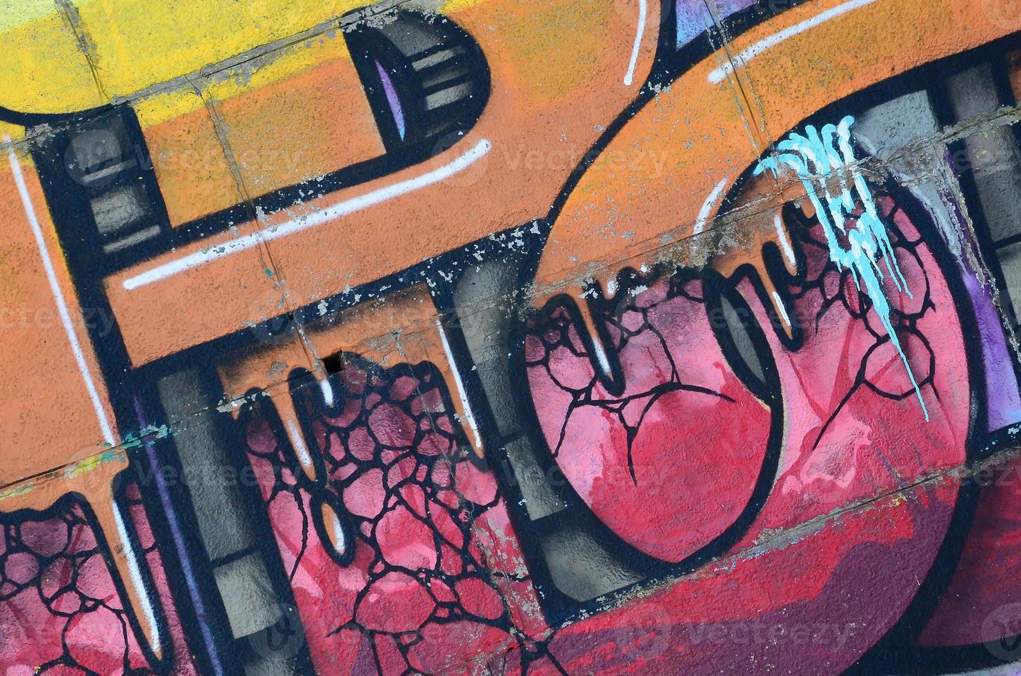 Fragment of graffiti drawings. The old wall decorated with paint stains in the style of street art culture. Colored background texture in warm tones photo