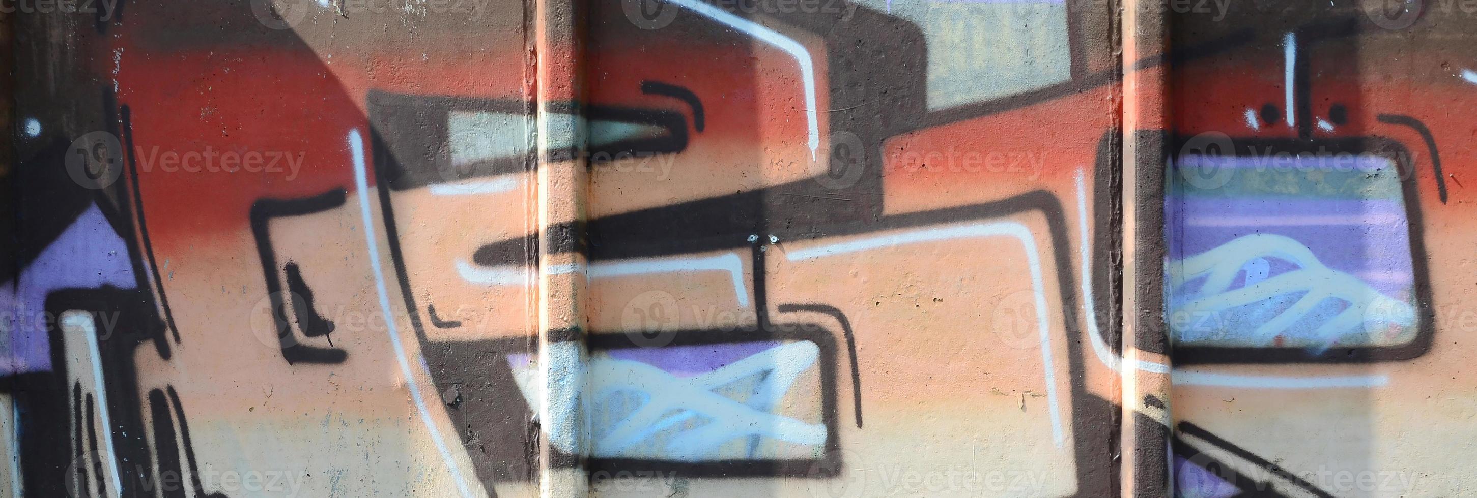 Fragment of graffiti drawings. The old wall decorated with paint stains in the style of street art culture. Colored background texture in warm tones photo