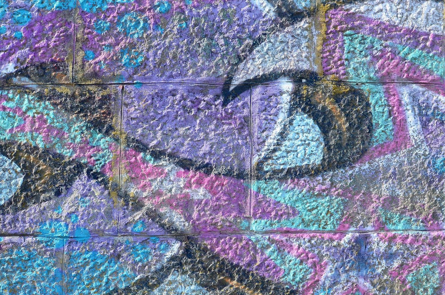 Fragment of graffiti drawings. The old wall decorated with paint stains in the style of street art culture. Colored background texture in purple tones photo